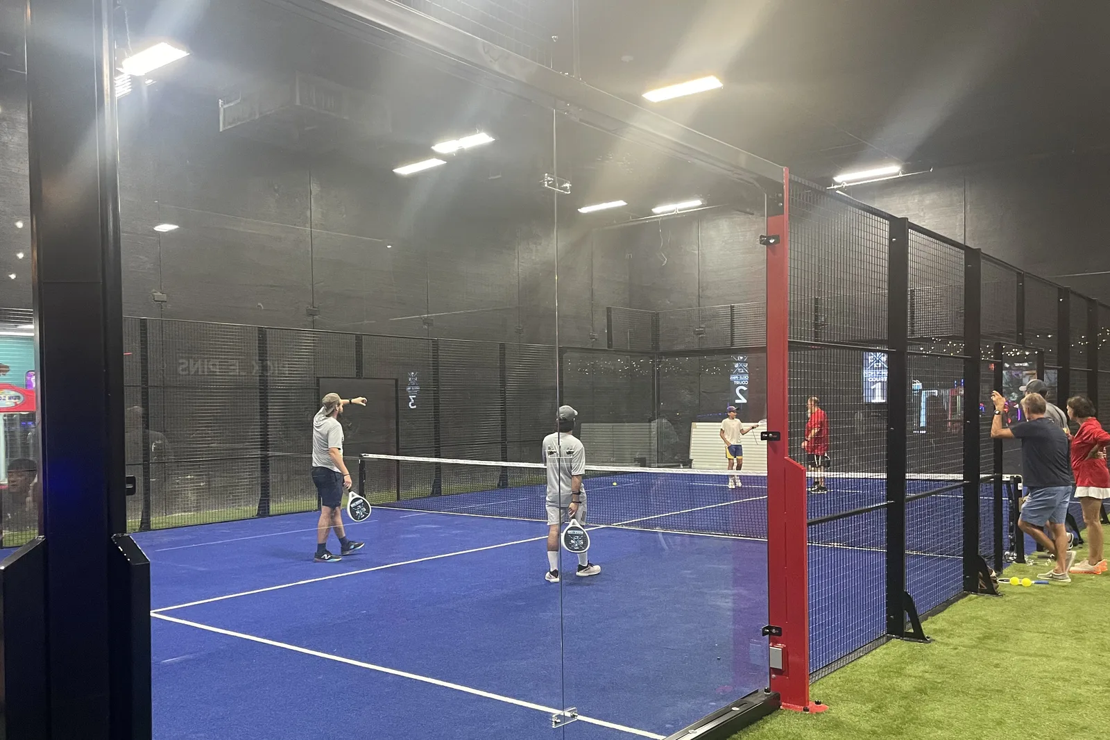 Doubles play on an indoor panoramic padel court in New Orleans, Louisiana